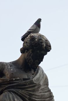 a statue of a man with a dove sitting on its head