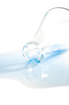 Blue liquid spilled from an erlenmeyer flask on a white background.