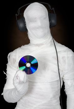 Man in bandage with ear-phones and disc on black