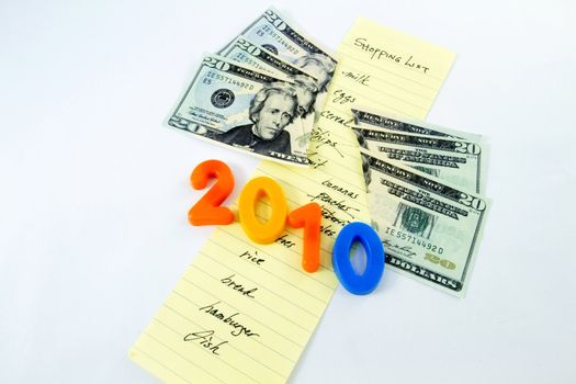 2010 numbers and cut dollars with a family shopping list of ordinary items, some crossed out, on a white background depict weakened consumer buying power in a recession year