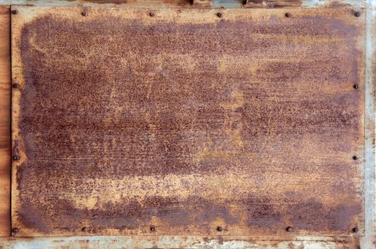 aged and weathered rusty metallic panel with screws