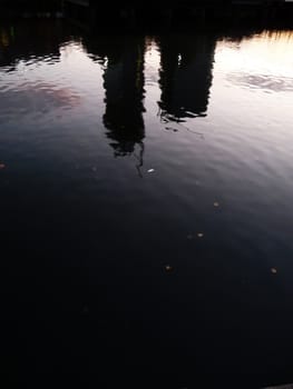 Distorted reflections of two buildings in some water.