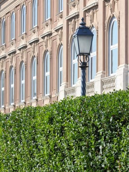 Street lights and building facade details and hedges.