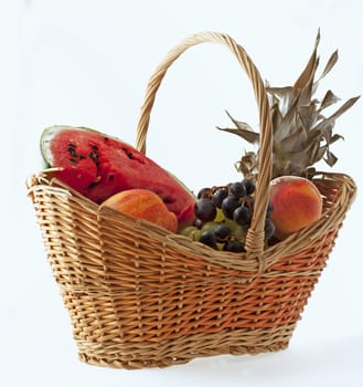 Basket of fruits with grape, ananans, water melon, peaches