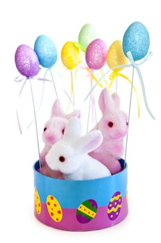 Cute Easter bunny toys in basket with balloons isolated on white background