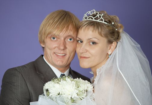 The first family portrait of the groom and the bride on violet background