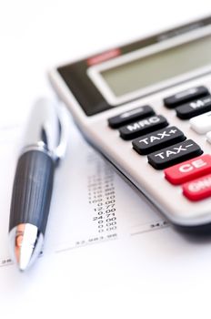 Calculating numbers for income tax return with pen and calculator