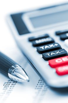 Calculating numbers for income tax return with pen and calculator