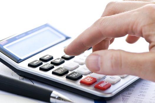 Typing  numbers for income tax return with pen and calculator
