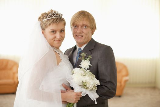 The groom and the bride in a solemn hall for wedding