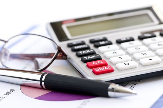 Calculating numbers for income tax return with glasses pen and calculator