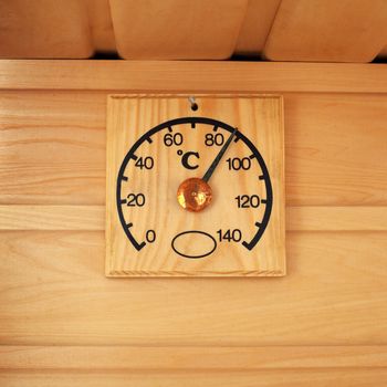 The wooden thermometer showing temperature in a sauna