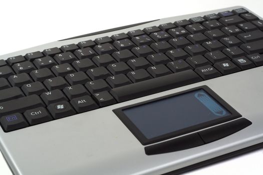 Close up on grey wireless keyboard with touchpad, isolated over white background