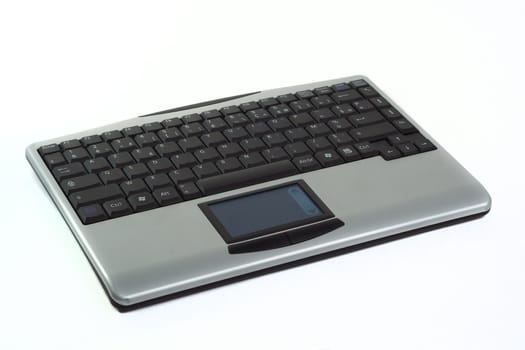 Grey wireless keyboard with touchpad, isolated over white background