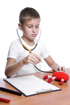 cute young boy playing doctor with pencil, heart, note pad 