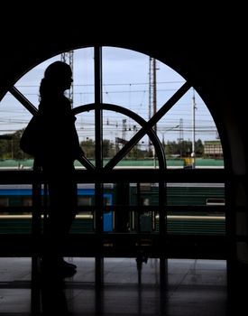 silhouette passenger woman opposite window railway station