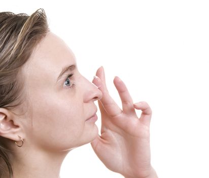 Young beautiful girl applying cream on her face on white