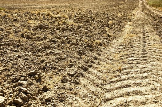 Fresh tractor track in the dirt on field