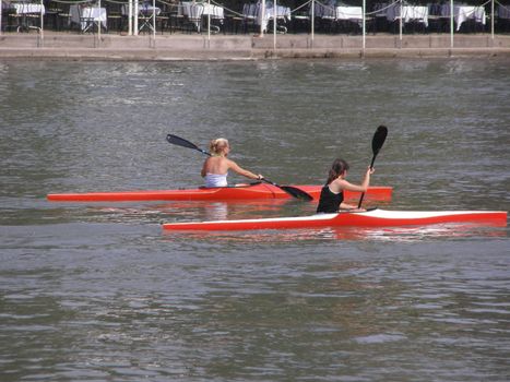 Two girl on canoe canoeing on a river