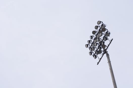 a stadium light, isolated on plain sky, with space for text or message.