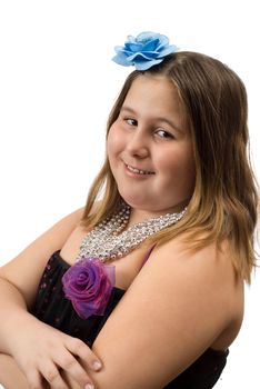 A cute female child wearing a dress and necklace, along with a flower hair piece, is posing isolated against a white background