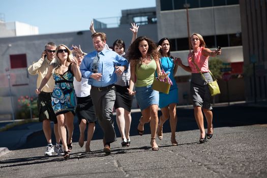 Group of hard working business men and women run down city street.