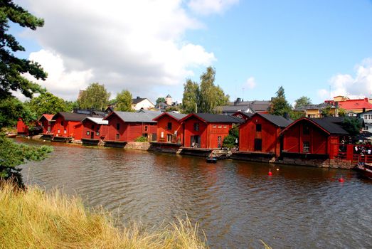 A tipical landscape in porvo, red houses and the river, with the blue cloudy sky in the background.