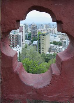 View of Santiago City through pattern in the wall at the top of Cerro de Santa Lucia in Santiago. 