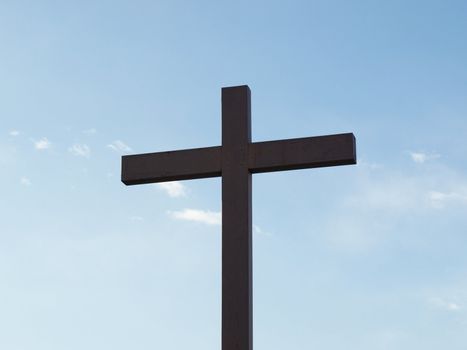 Wooden cross over a blue sky with clouds