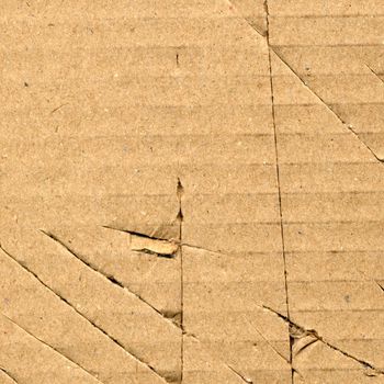 Brown torn corrugated cardboard sheet background with cuts