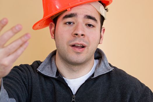 This young construction worker has his hard hat on sideways.
