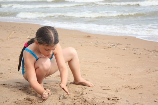  Little girl on the beach building sand castle