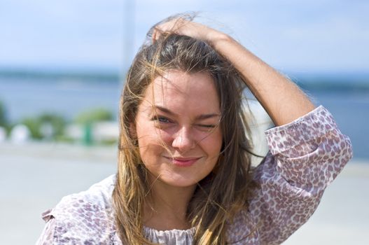 Cute attractive women smiling at the beach. Summer portrait. Blurring background.