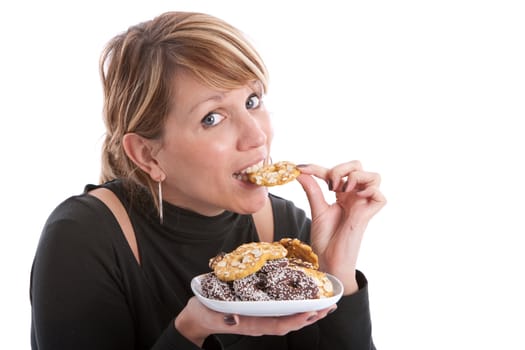 Pretty blond woman taking a bite out of a cookie
