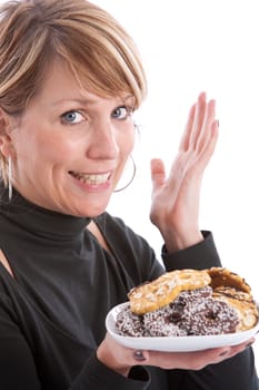 Woman holding up a plate of christmas cookies and making a yummy gesture