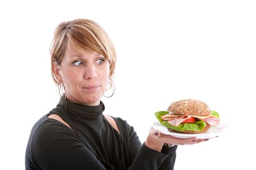 Pretty blond woman looking at her healthy sandwich