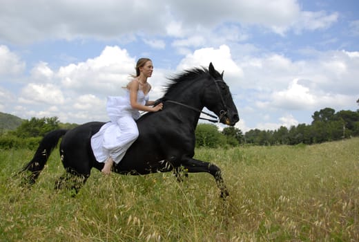 galloping beautiful wedding woman on her black stallion