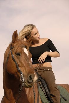 riding girl and her brown stallion. focus on the teen