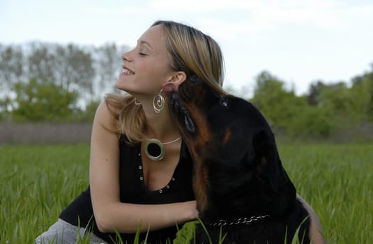 laughing young woman and her purebred rottweiler