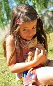 little girl and kitten in a garden
