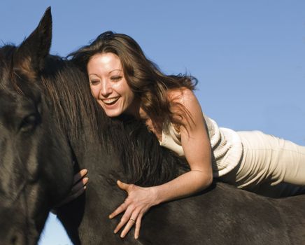 happy young woman and her best friend black stallion