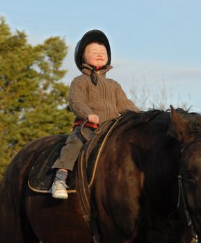 little boy and her black stallion happy... focus on the head of child