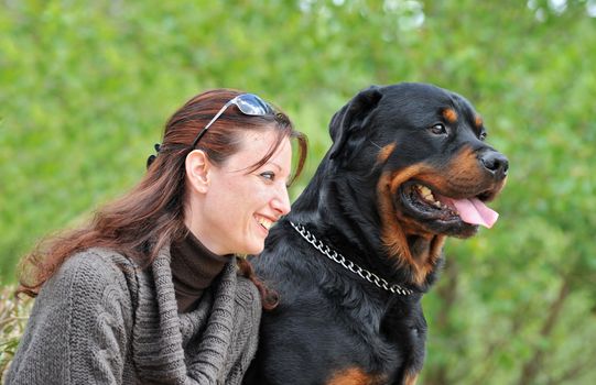 beautiful smiling young woman and her purebred rottweiler
