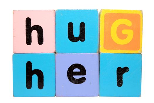 assorted childrens toy letter building blocks against a white background that spell hug her with clipping path