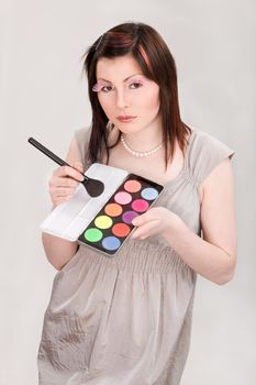 Young girl with faked lashes holding color palette