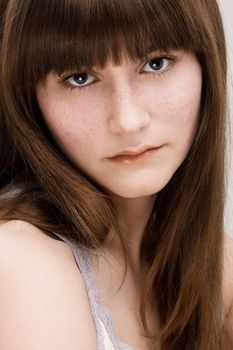 Desaturated portrait of young beautiful girl with freckles