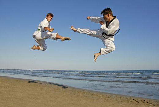 training of the two young men on the beach: taekwondo, martial sport