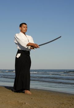 a young man are training in Aikido on the beach