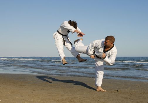 training of the two young men on the beach: taekwondo