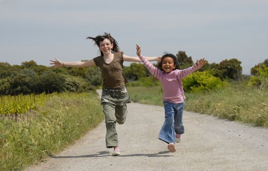 two sisters running in a little road in the nature 